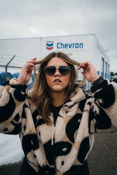 A lady standing in front of Chevron truck