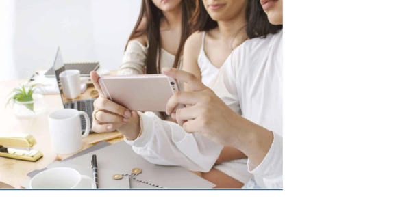 three women looking at a phone